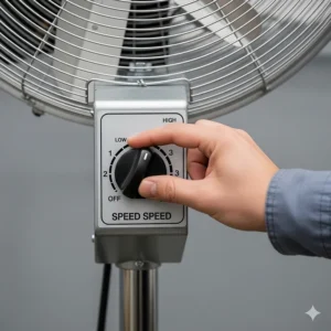 A user's hand adjusting the speed control knob on a powerful 30 industrial pedestal fan, showcasing its multiple speed settings for customized airflow.
