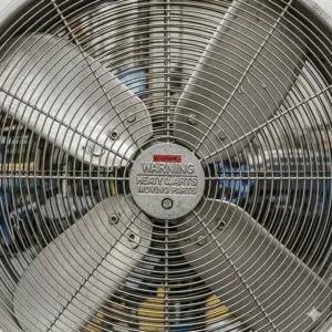 Detailed view of the durable metal fan blades and safety grille on an industrial oscillating fan.