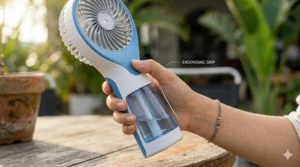 A person holding a handheld misting fan showing the comfortable non-slip handle grip.