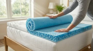 A user unrolling a blue gel cooling mattress topper on top of a standard mattress for an instant comfort upgrade.