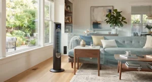 A smart tower fan shown with its remote control on a modern side table.