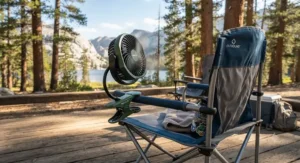 A versatile clip-on battery fan for camping attached securely to a folding camp chair on a sunny day.